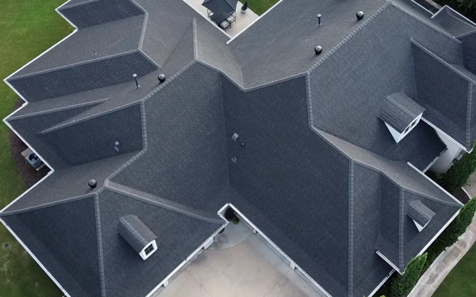 Overhead view of a finished charcoal shingle roof with crisp ridge lines and valleys